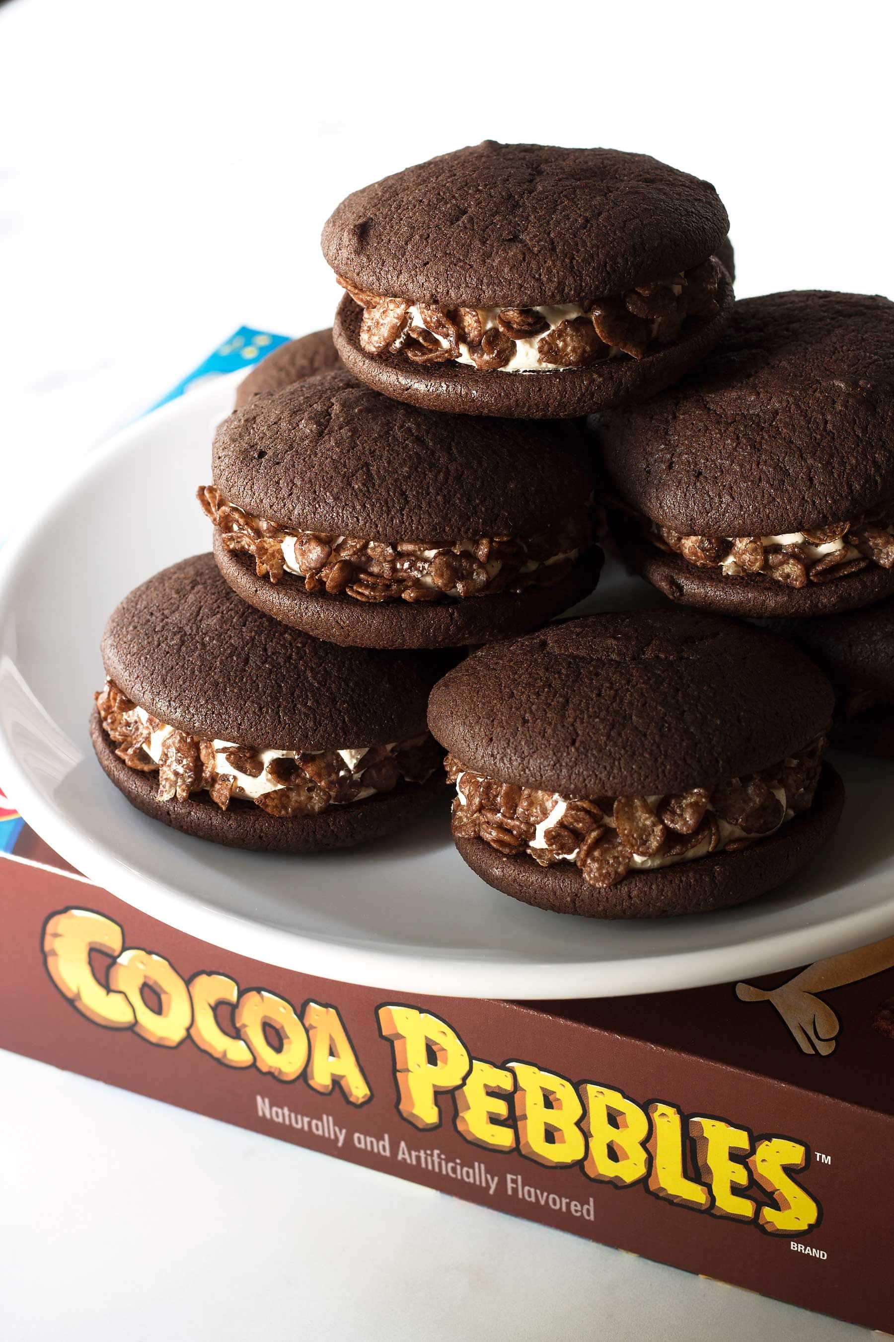 Easy to make and so fun! These delicious chocolaty whoopie pies have a luscious Swiss meringue buttercream and are rolled in crispy Cocoa PEBBLES™ for a nice crunch! And it's all gluten free! This recipe is the perfect dessert to round out a fun family weekend. #glutenfree #ad #glutenfreebaking #maple #coconutsugar #glutenfreedessert #glutenfreewhoopiepies #whoopiepies #buttercream #swissmeringuebuttercream #cocoapebbles #paleoish #holidaybaking #breakfastcereal #nostalgia 
