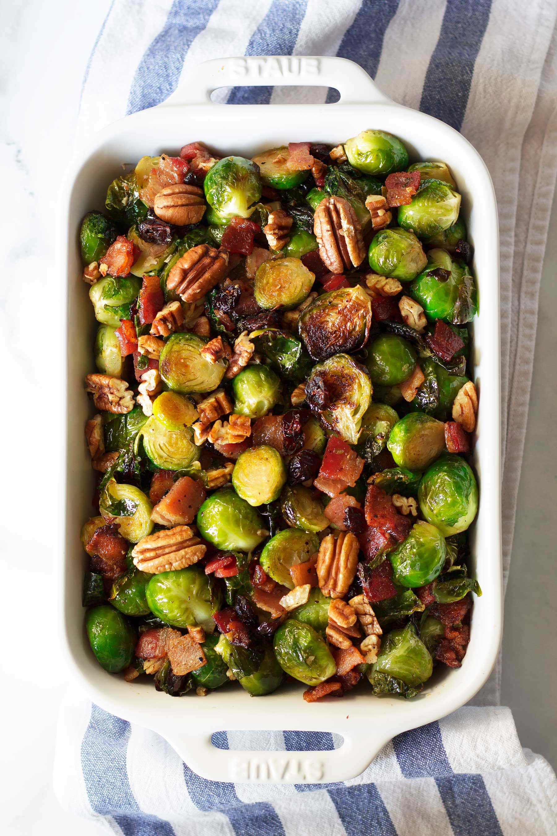 This quick holiday side dish is perfect for Thanksgiving and Christmas! These Maple Bacon Brussels Sprouts with Pecans and Cranberries are sure to be a hit on your holiday table. This paleo Thanksgiving recipe is also gluten free, dairy free, and can be made low carb and keto! #thanksgivingsidedish #healthythanksgiving #healthychristmas #brusselssprouts #bacon #maplesyrup #lakanto #cranberries #crasins #pecans #glutenfreethanksgiving #glutenfree #dairyfree #ketothanksgiving #ketochristmas #ketosidedish