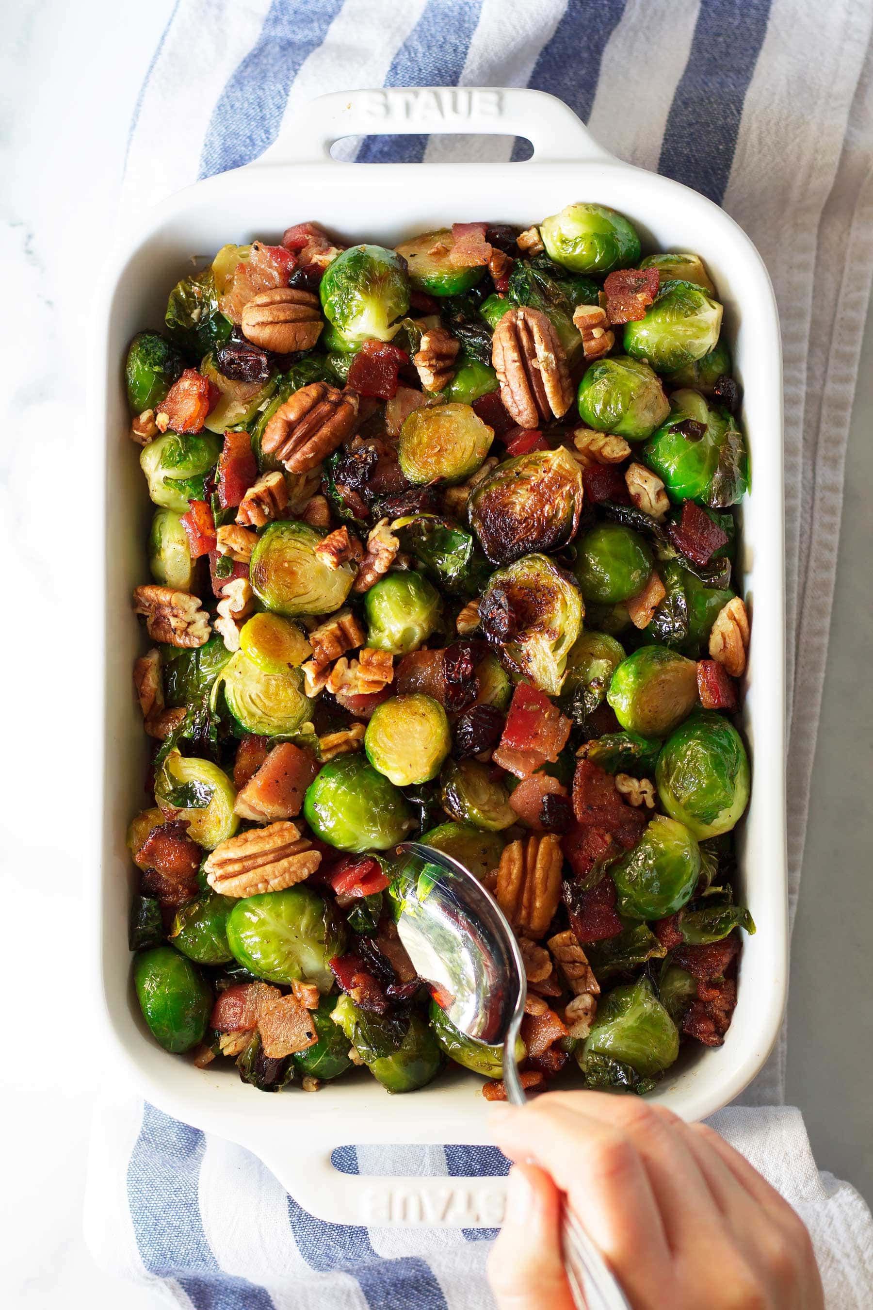 This quick holiday side dish is perfect for Thanksgiving and Christmas! These Maple Bacon Brussels Sprouts with Pecans and Cranberries are sure to be a hit on your holiday table. This paleo Thanksgiving recipe is also gluten free, dairy free, and can be made low carb and keto! #thanksgivingsidedish #healthythanksgiving #healthychristmas #brusselssprouts #bacon #maplesyrup #lakanto #cranberries #crasins #pecans #glutenfreethanksgiving #glutenfree #dairyfree #ketothanksgiving #ketochristmas #ketosidedish