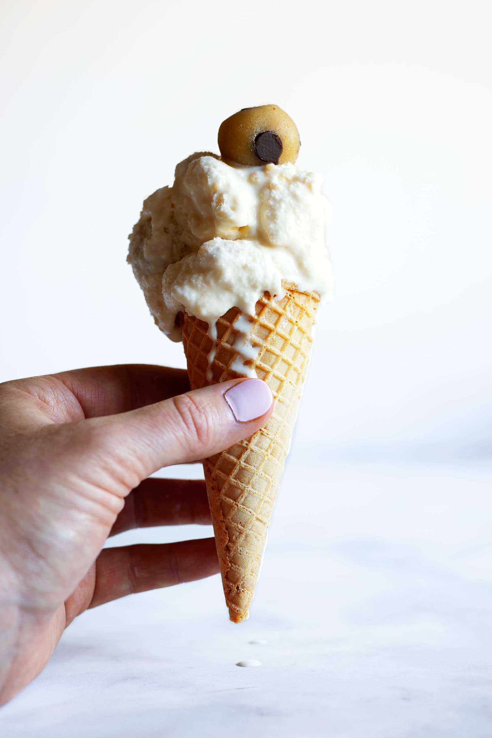 person holding a cone with ice cream