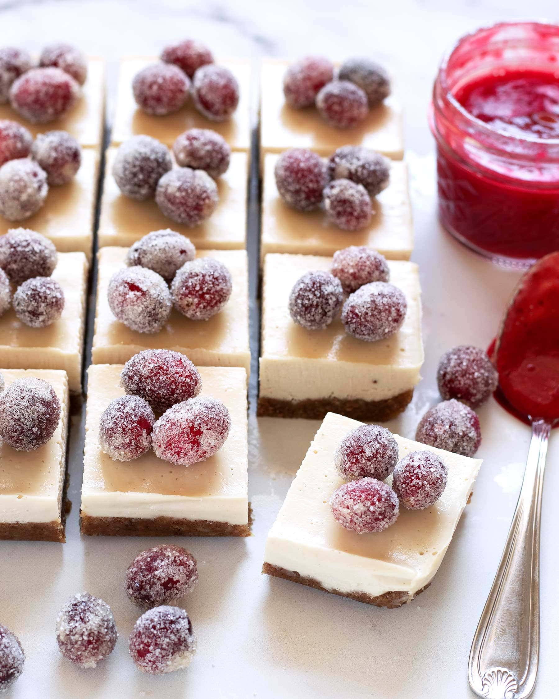 slices of No-Bake Christmas Cheesecake Bars with cranberries and spoon