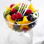 fruit salad in glass cup with with fork