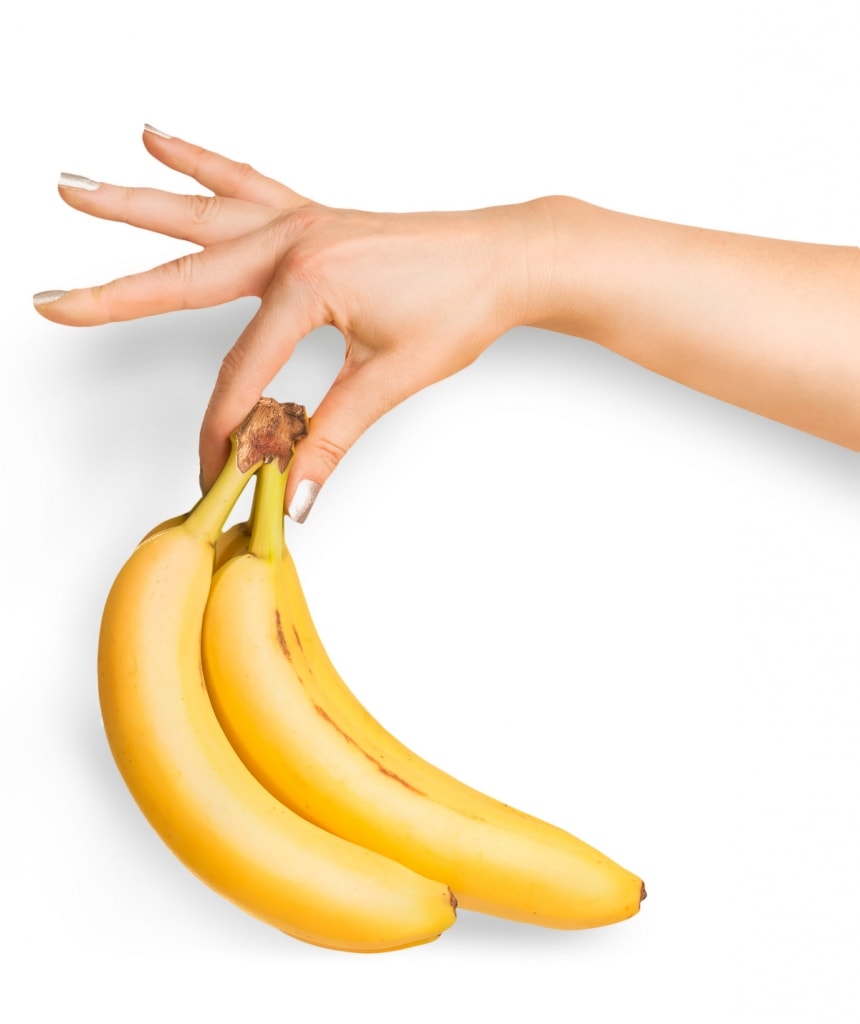 Bunch of organic bananas in female hand - a Healthy alternative to sugar in coffee