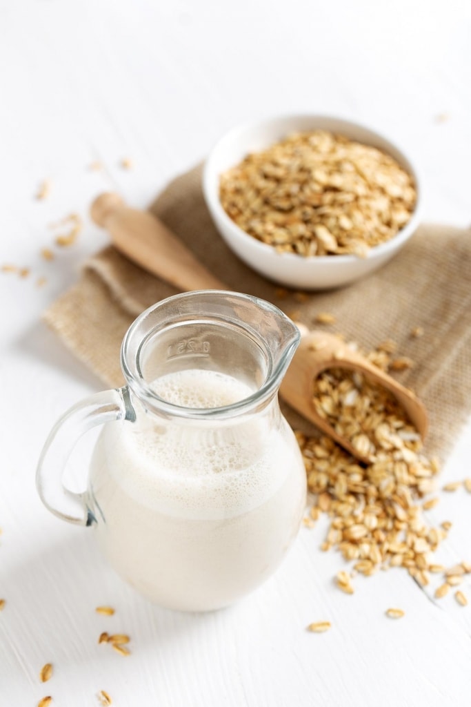 Oat milk. Healthy vegan non-dairy organic drink with flakes 