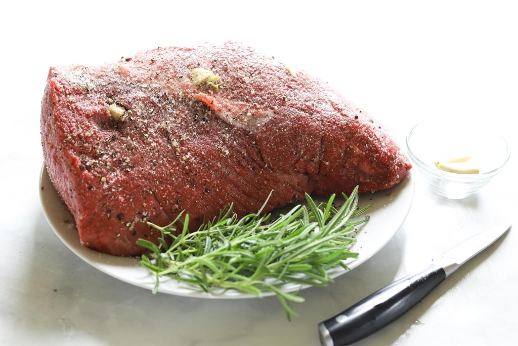 raw roast beef with garlic stuffed in slits