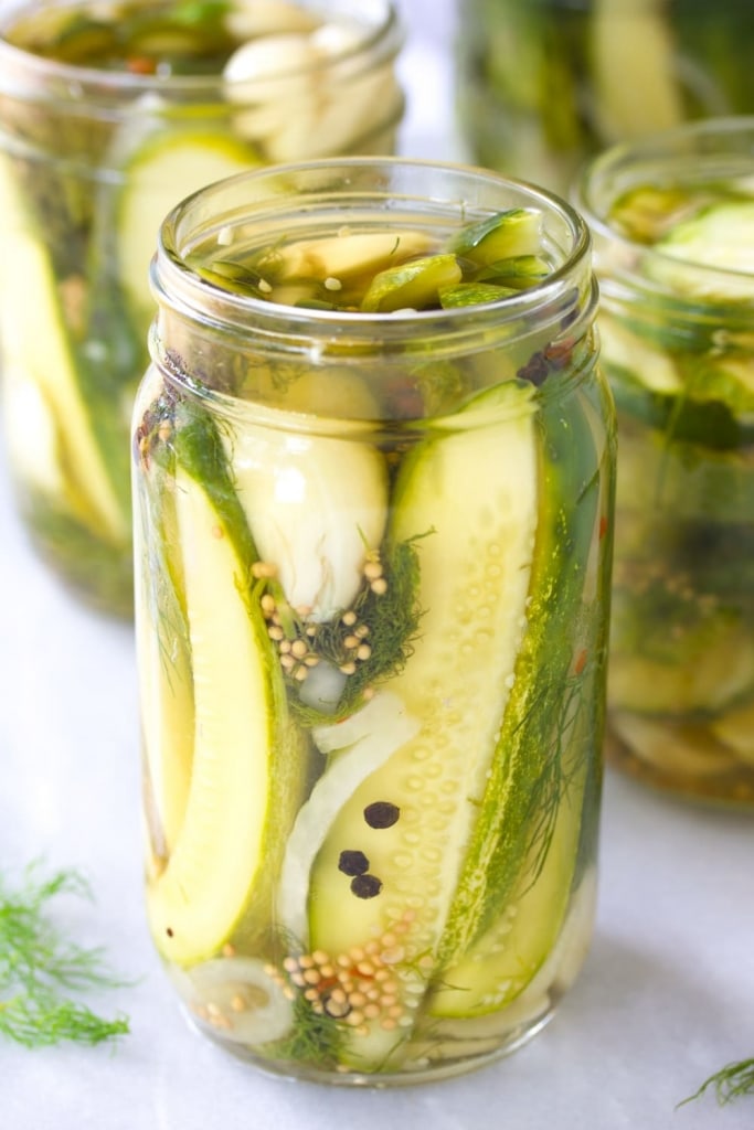 cucumbers in jars on white countertop