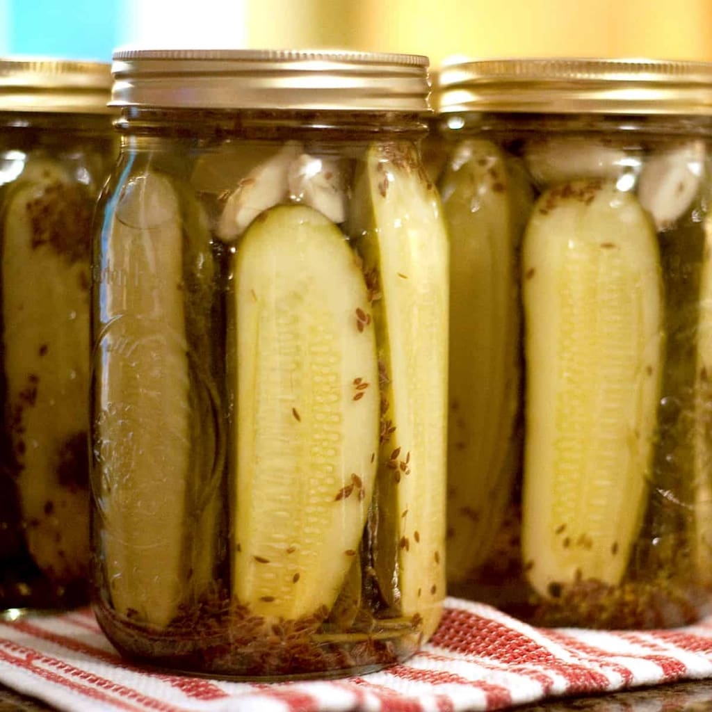 pickles in jars on red and white kitchen towel