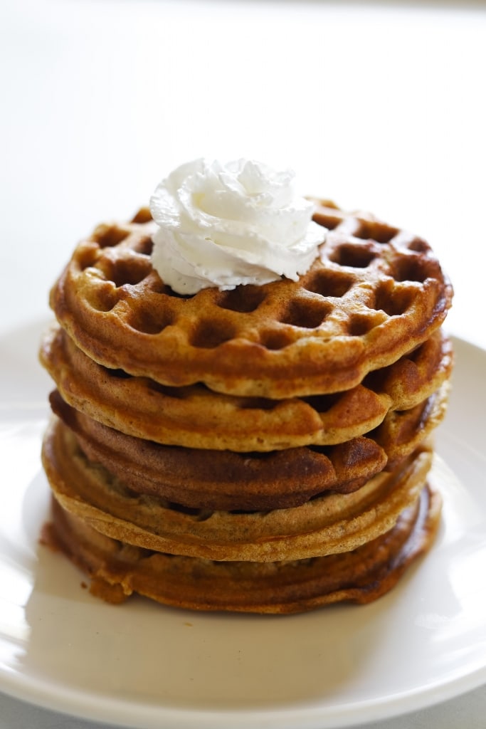 gluten free pumpkin waffle recipe stacked with whipped cream