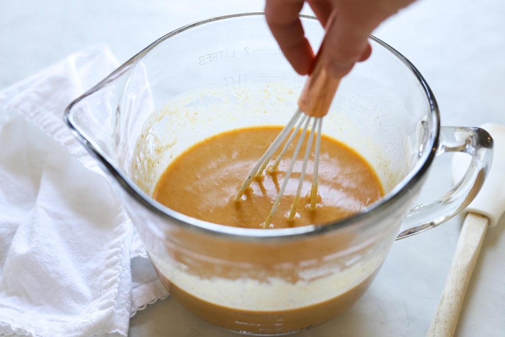 whisking wet ingredients in large glass measuring cup