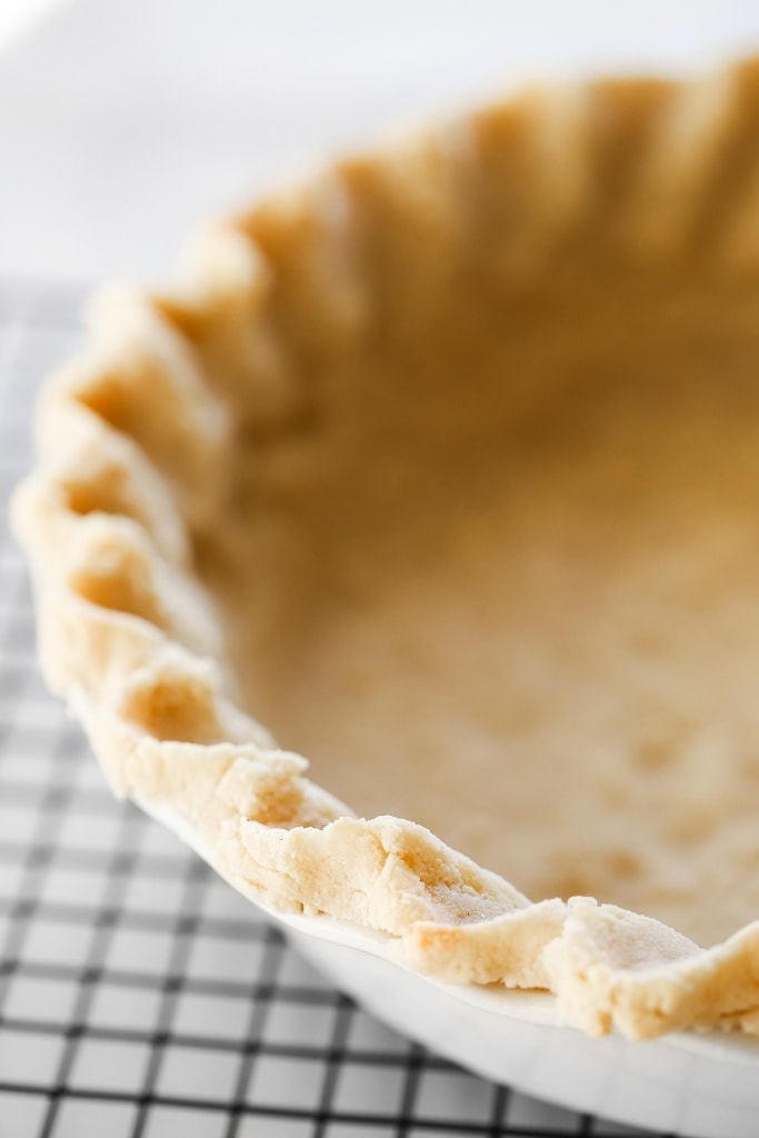 baked pie crust in white pan on cooling rack