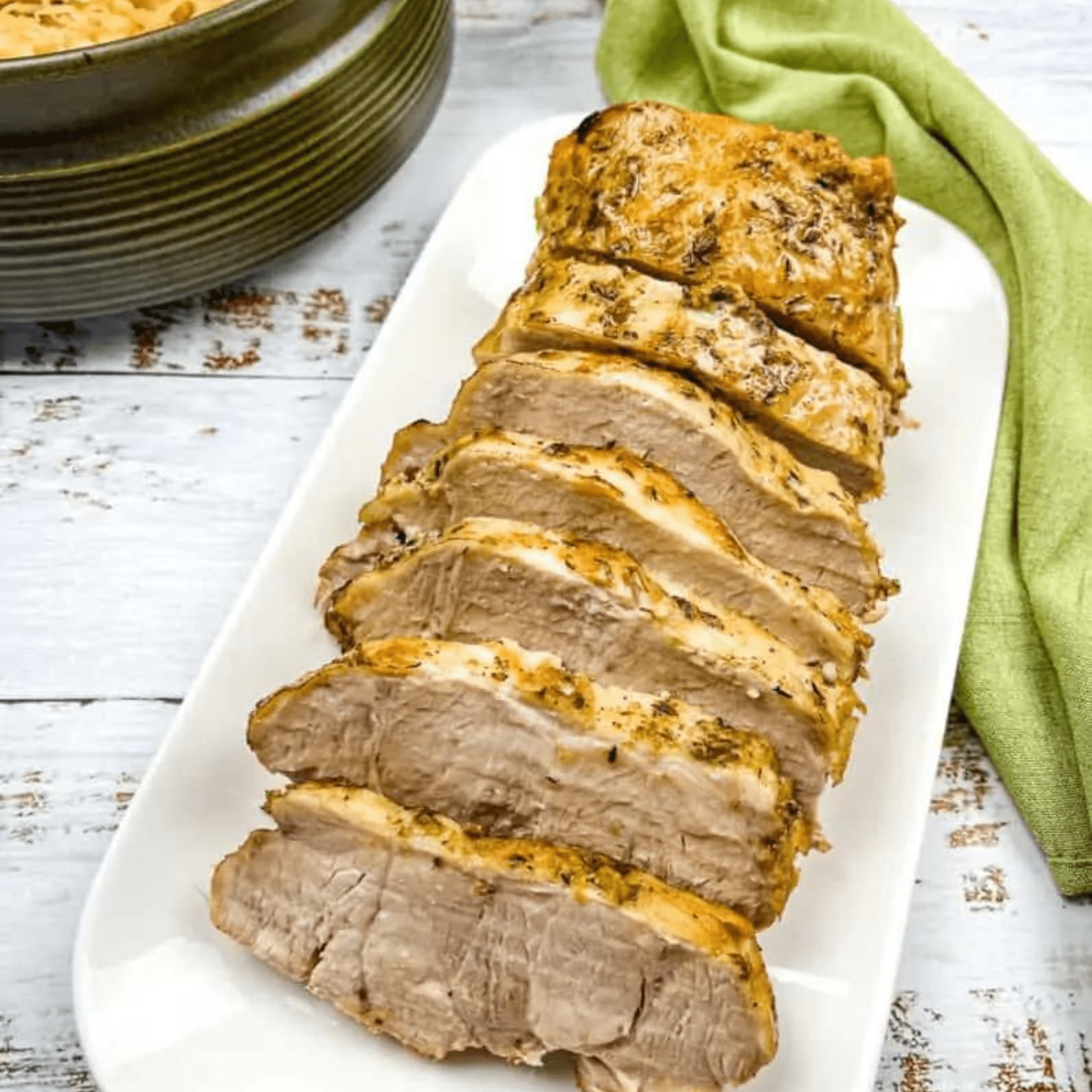 German pork loin with mustard on a white platter.