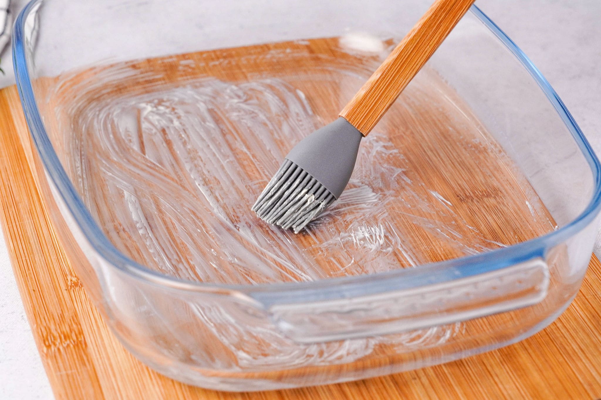 greasing baking dish with butter