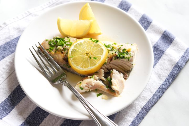 halibut on plate with lemon slice