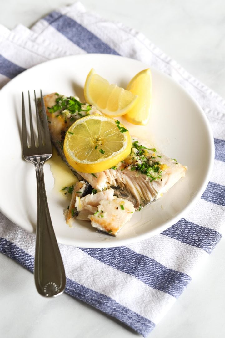halibut on plate with lemon and fork