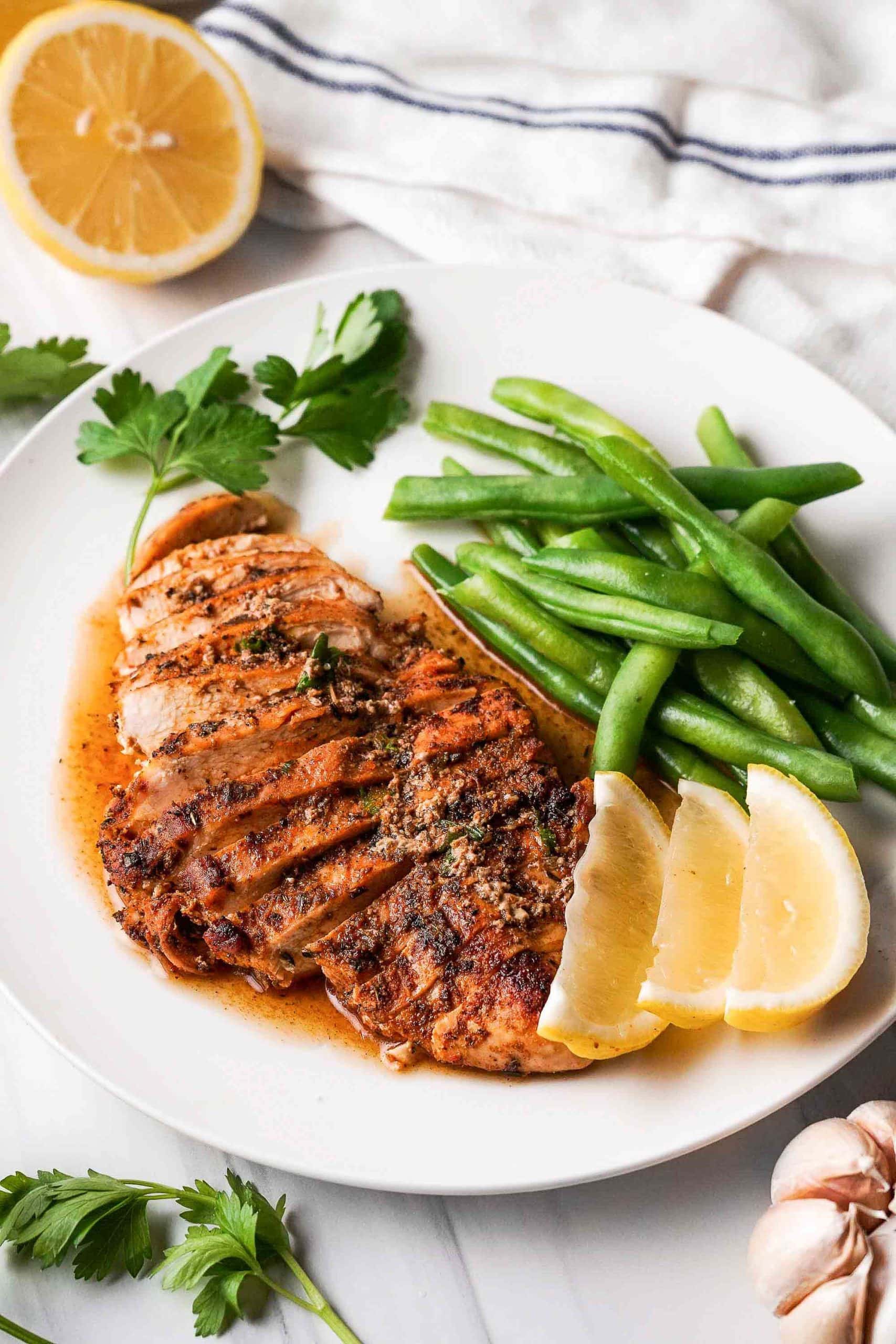 sliced chicken breast on plate with green beans