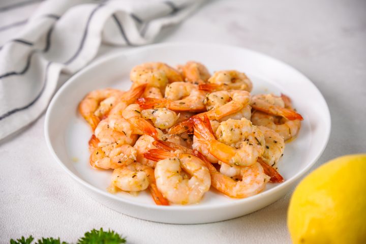 finished shrimp on white plate before garnishing with white background and dish towel