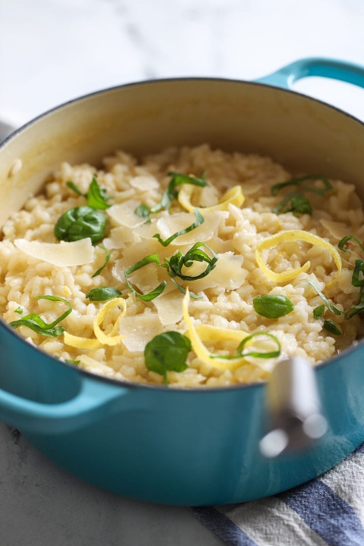 lemony risotto in blue le creuset pot side angle with serving spoon